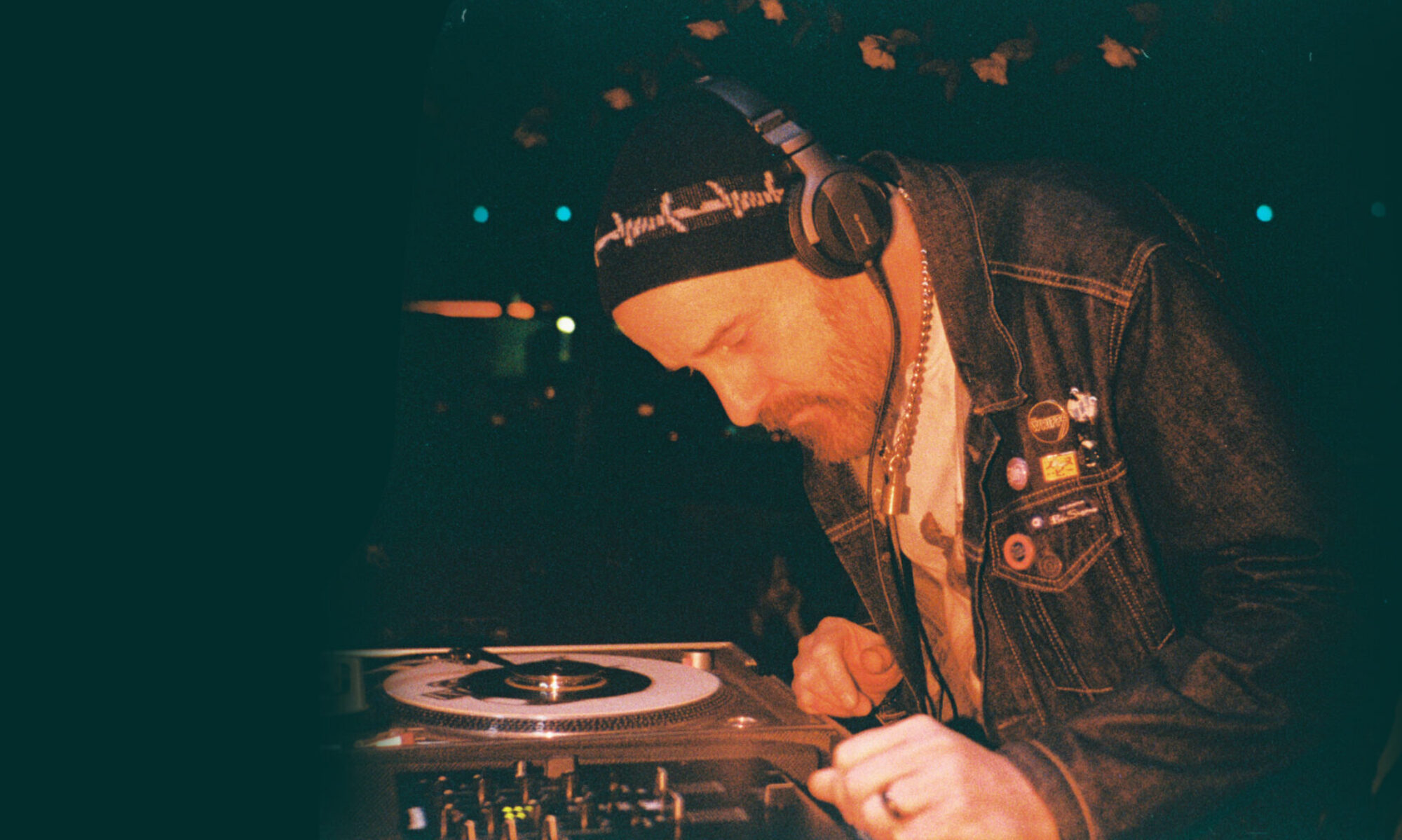 DJ Scotty Upton, The Grackle bar, Austin, Texas, selecting and spinning vinyl records. Photograph by Mathew Jeanes, taken with a Lomomatic 110 film camera, with colored flash gel.